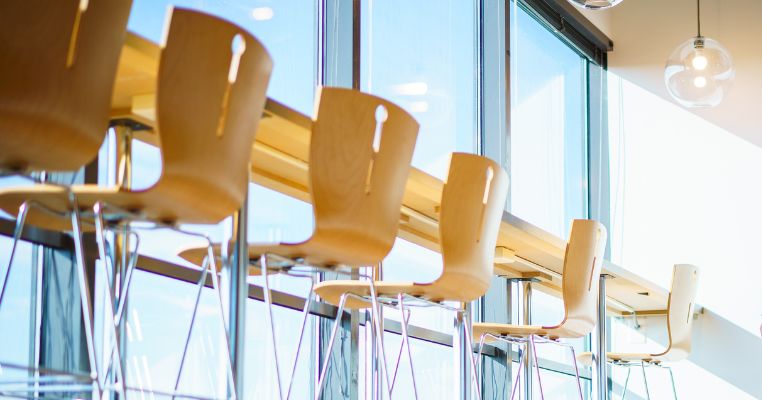 Sun streaming through windows at kitchen counter with chairs