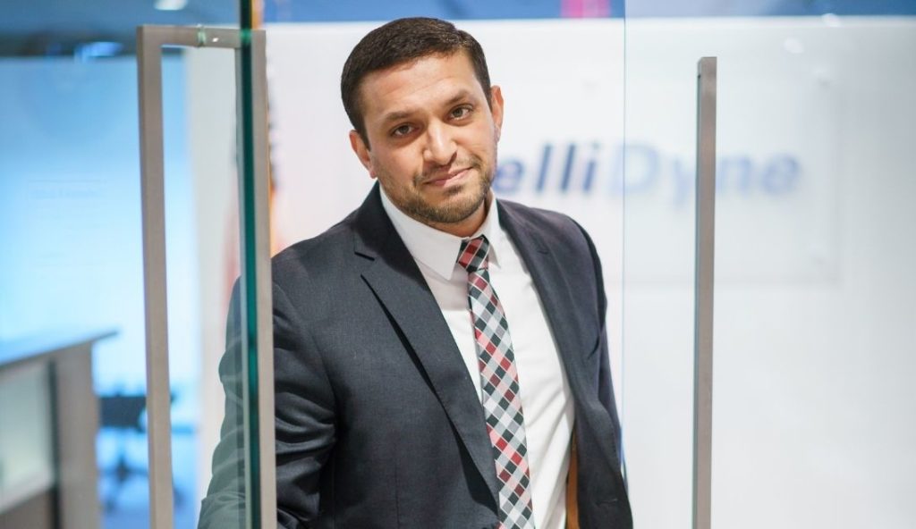 IntelliDyne employee opening glass door to lobby